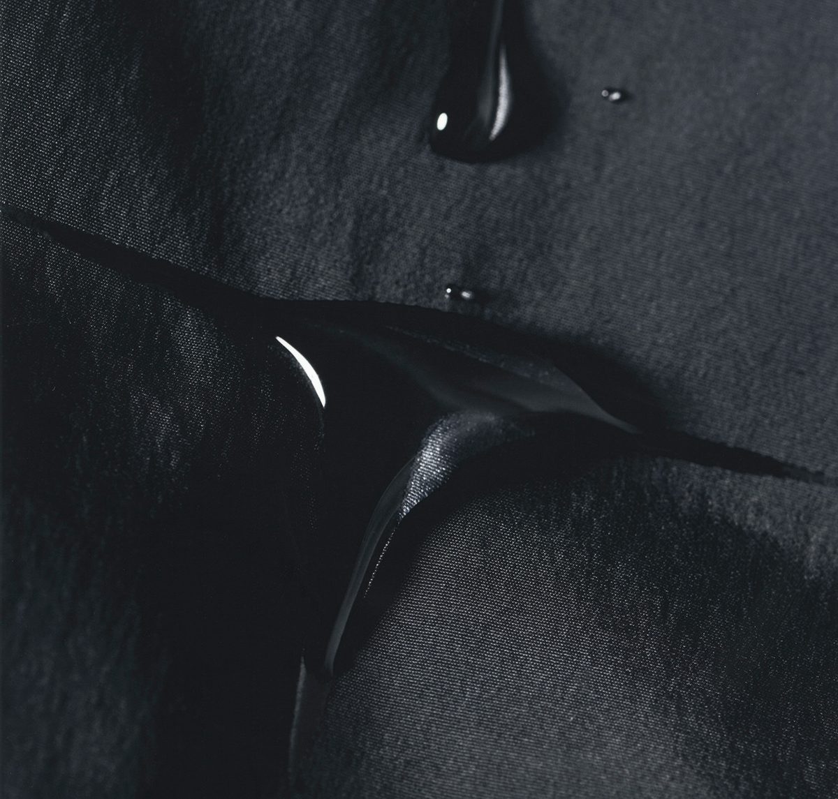 Detail of a dark technical fabric with water drops