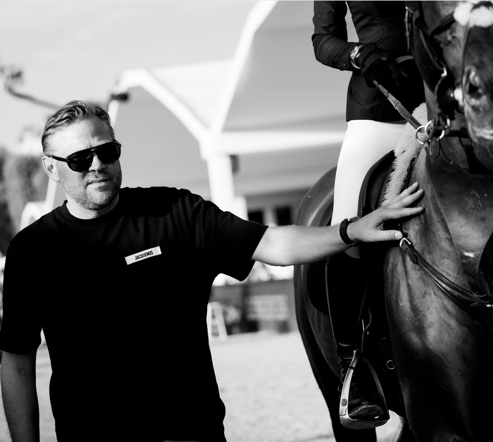 Ulrich Trolle beside a horse and rider at a showjumping arena
